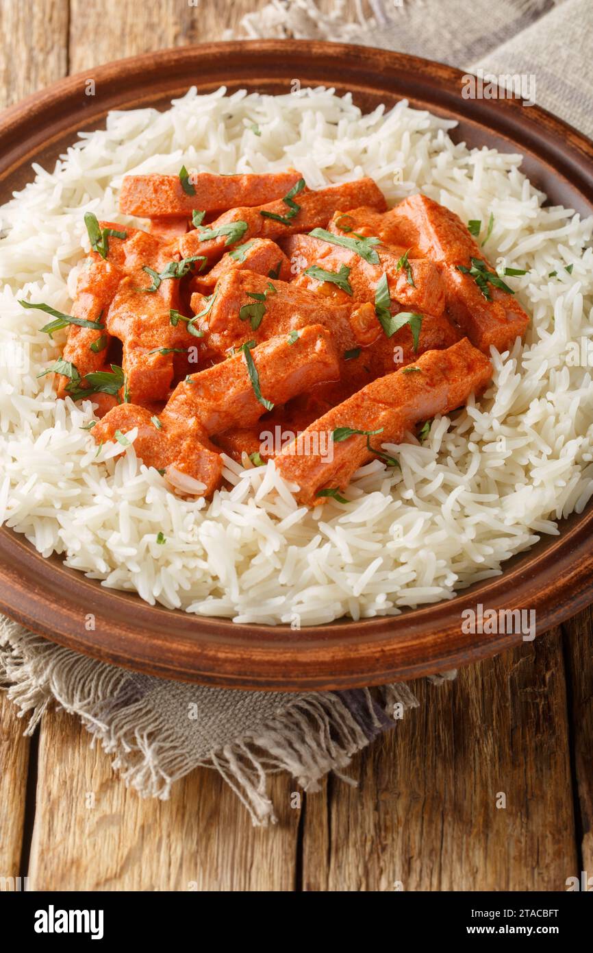 Salsiccia svedese Korvstroganoff Stroganoff con primo piano di riso sul piatto sul tavolo. Verticale Foto Stock