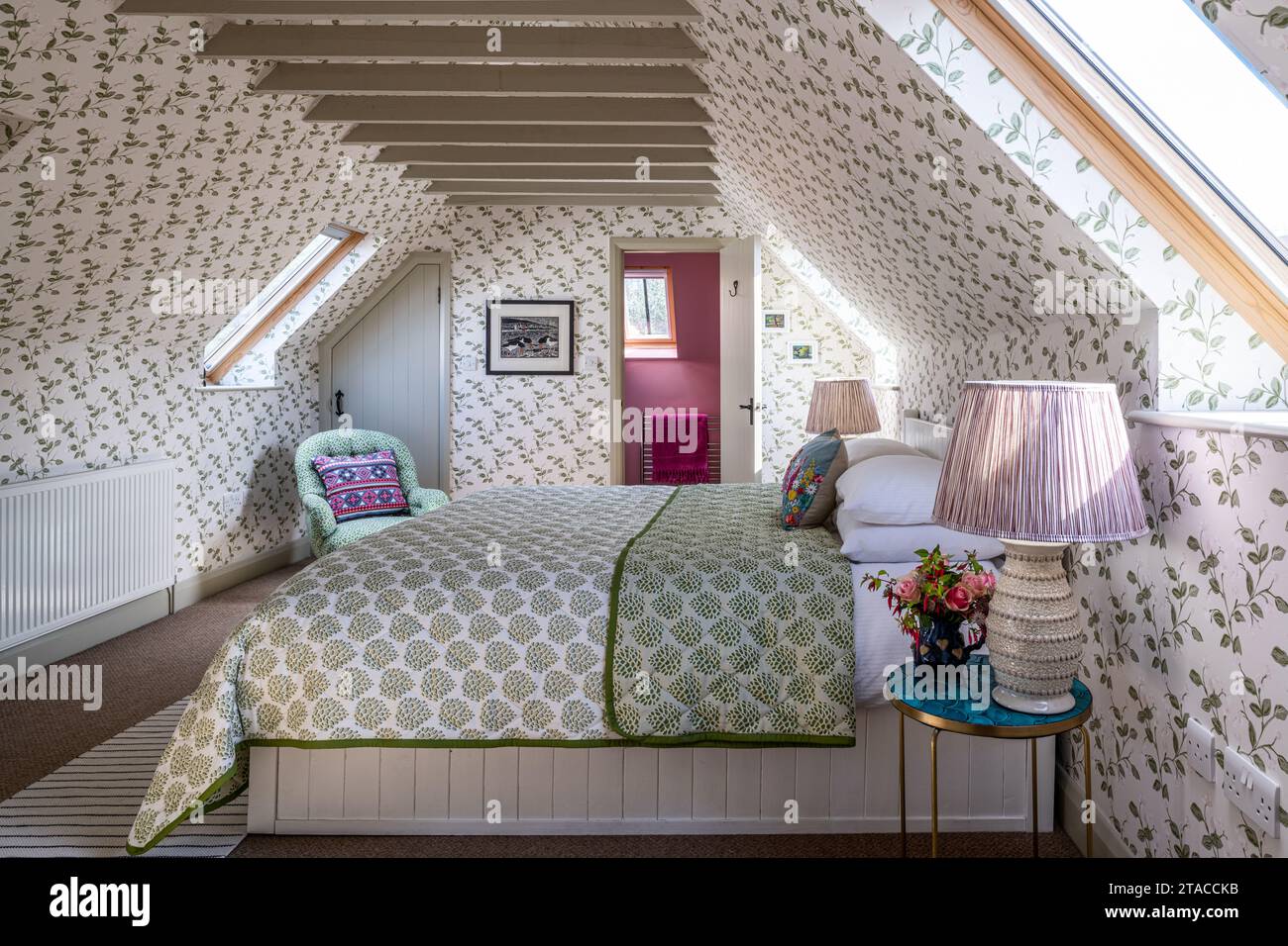 Camera da letto mansardata con design in tessuto e carta da parati di Eloise Home in stile Arts and Crafts anni '1930. Hove, East Sussex, Regno Unito. Foto Stock
