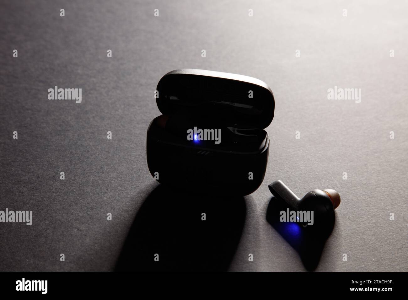 una ripresa in studio di un paio di auricolari bluetooth wireless jbl neri, su uno sfondo nero incredibilmente illuminato Foto Stock