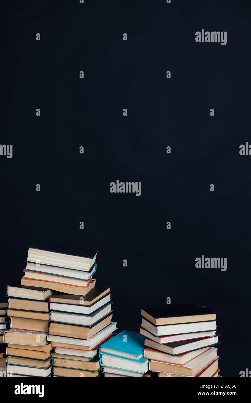 Tantissimi vecchi libri educativi su una libreria a sfondo nero Foto Stock