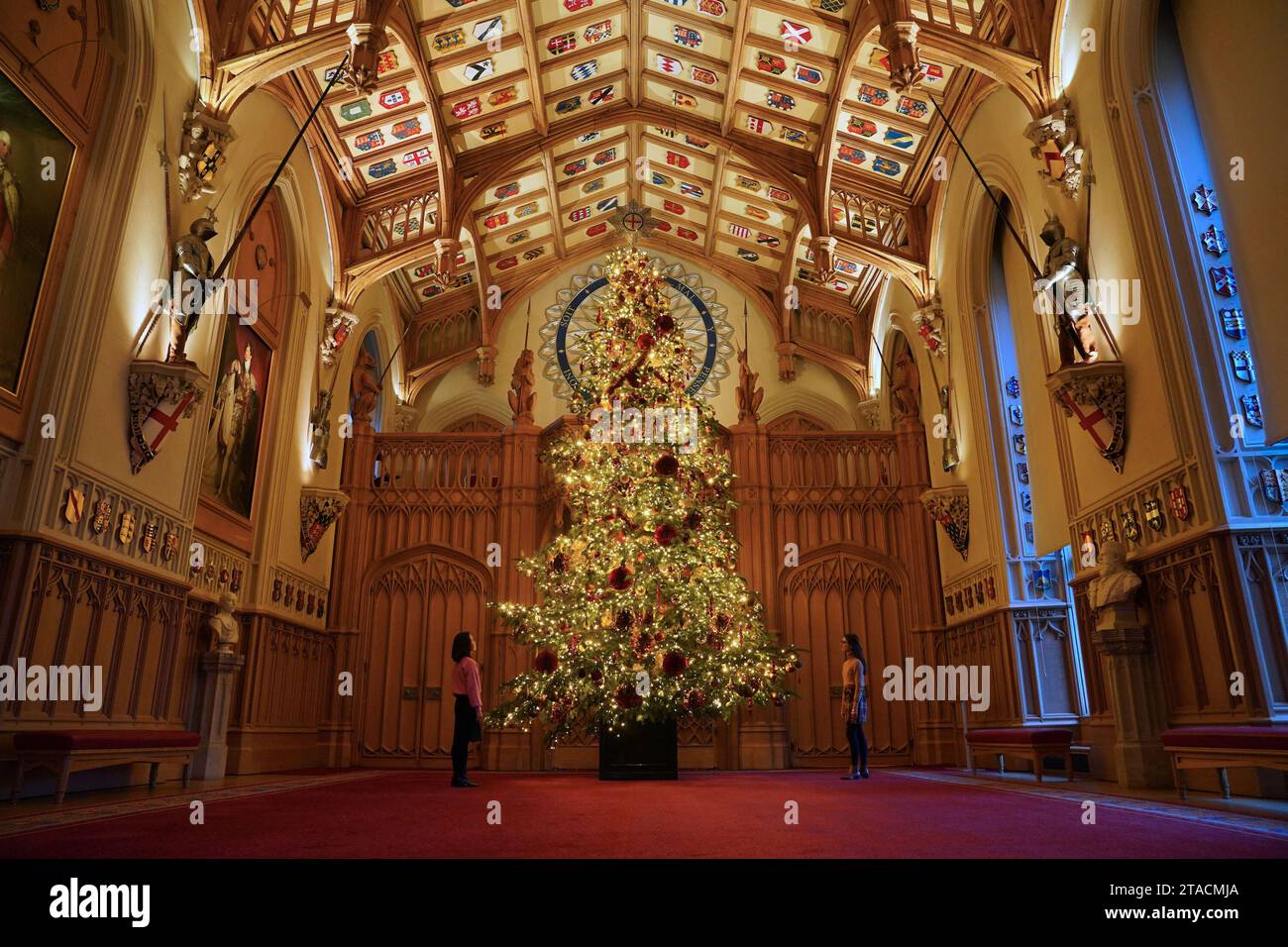 Il personale del Royal Collection Trust aggiunge gli ultimi ritocchi a un albero di Natale nella St George's Hall durante una foto per le decorazioni natalizie al Castello di Windsor, Berkshire. Data foto: Giovedì 30 novembre 2023. Foto Stock