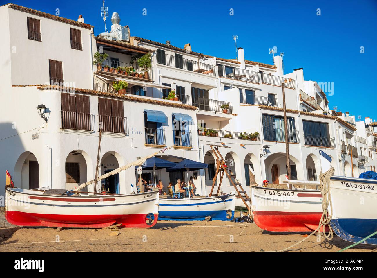 L'originale villaggio turistico di Calella de Palafrugell con barche a vela sulla sua spiaggia sabbiosa sulla Costa Brava, Girona, Spagna Foto Stock
