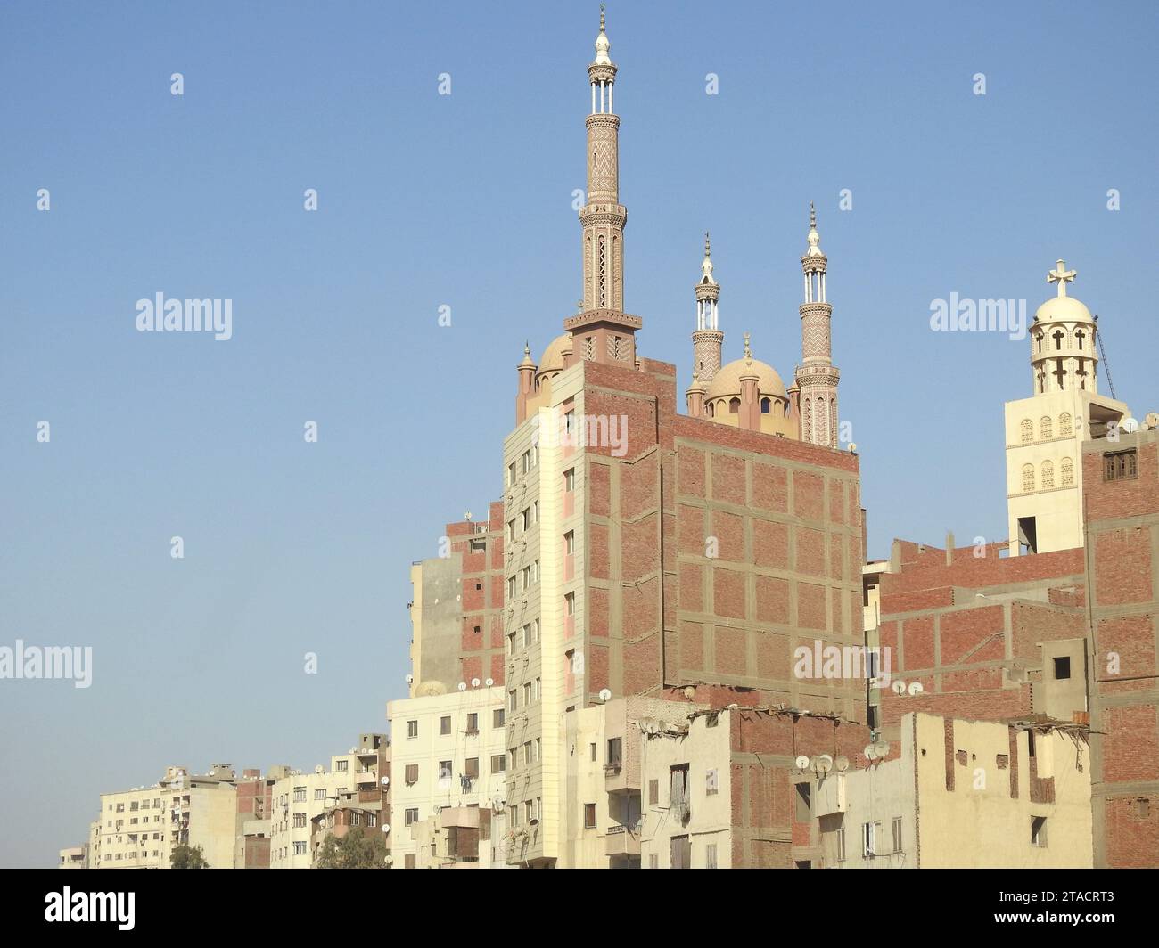 Giza, Egitto, settembre 28 2023: Cupole, minareti sopra un edificio, una moschea, minareti e cupole sopra un alto edificio, accanto a un campanile della chiesa, è Foto Stock