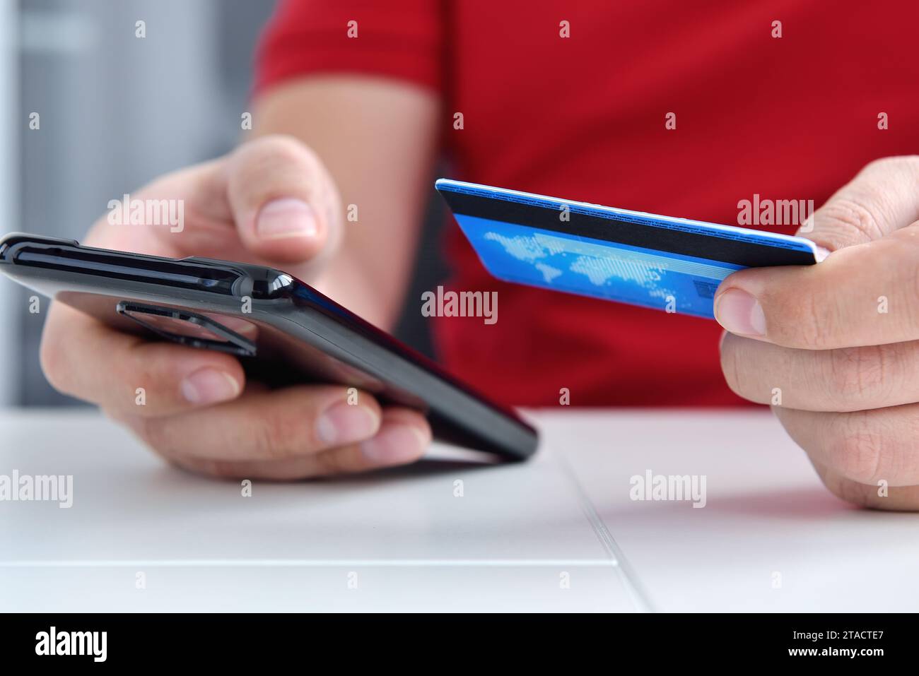 Le mani immettono i dati della carta di credito nel telefono cellulare per l'acquisto. Pagamento online e concetto di e-commerce. Primo piano Foto Stock