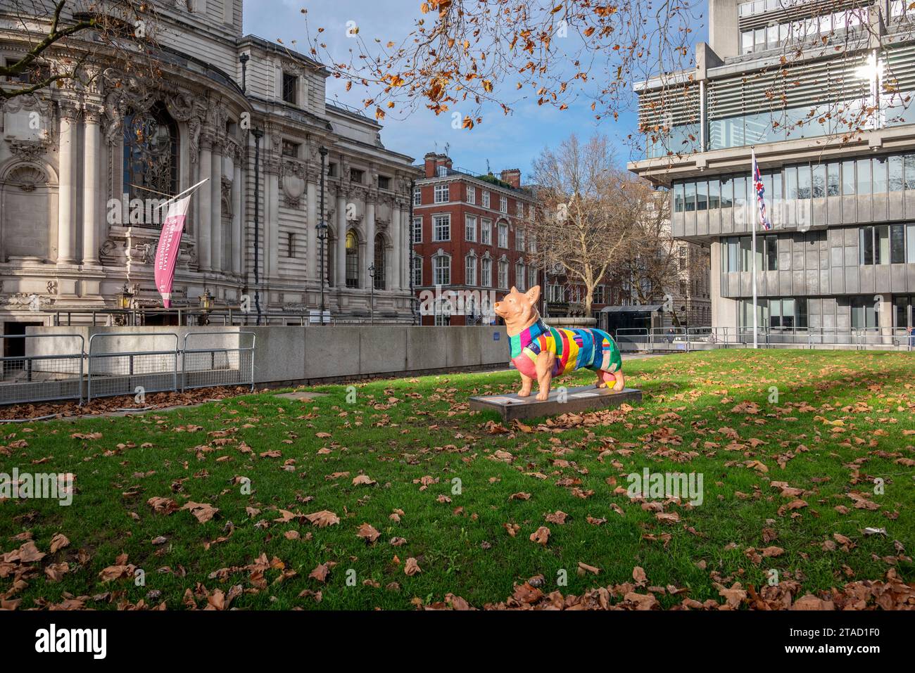 Statua di un cane corgi che indossa un cappotto colorato nei giardini del Queen Elizabeth II Centre, Westminster, Londra Foto Stock