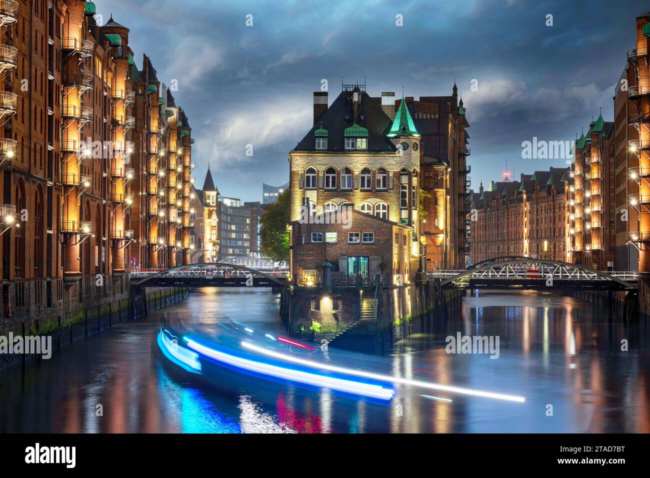 Castello illuminato nel quartiere storico dei magazzini di Amburgo nell'ora blu dopo il tramonto Foto Stock