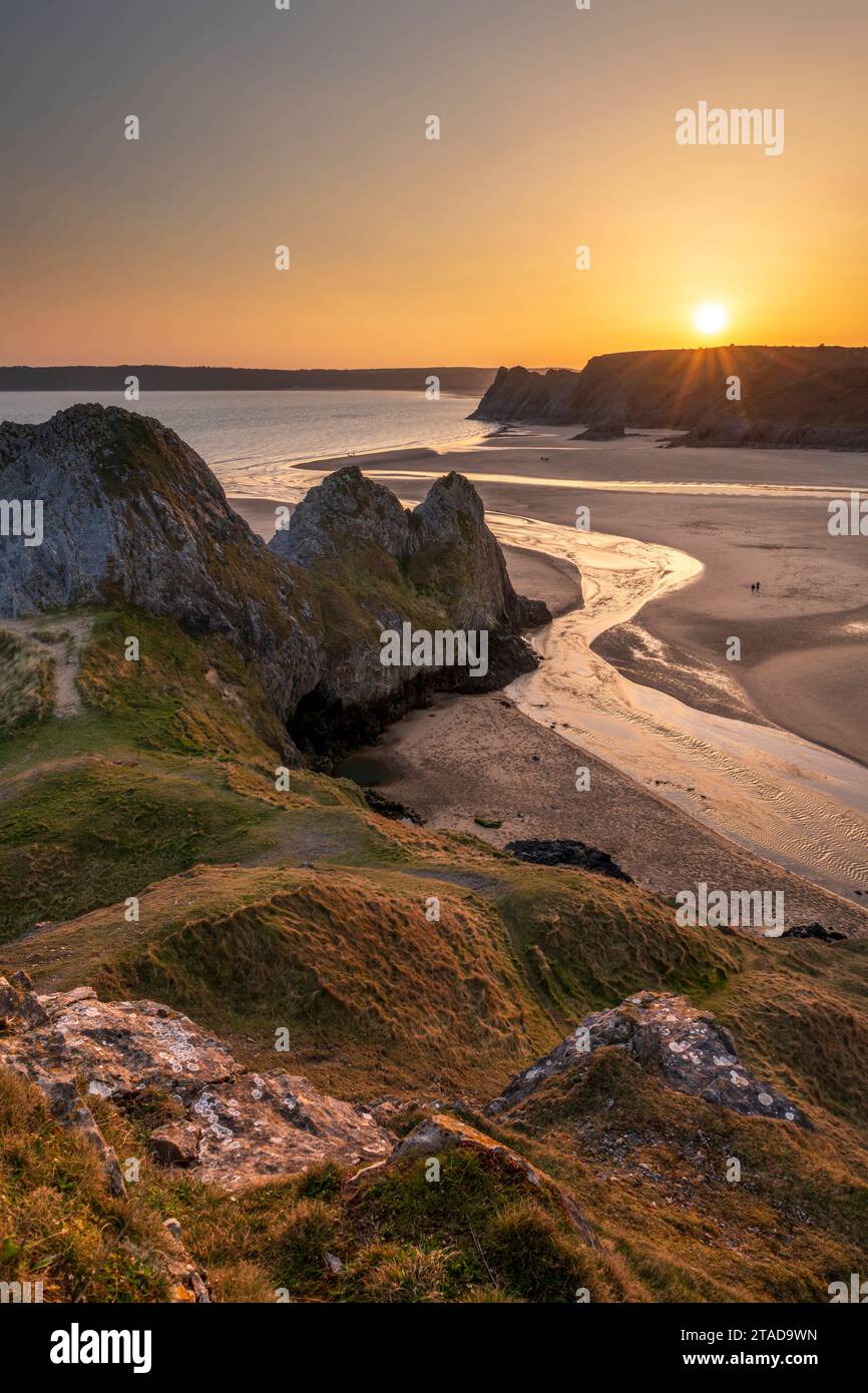 Tramonto dorato su Three Cliffs Bay sulla penisola di Gower, Galles del Sud, Regno Unito. Primavera (marzo) 2022. Foto Stock