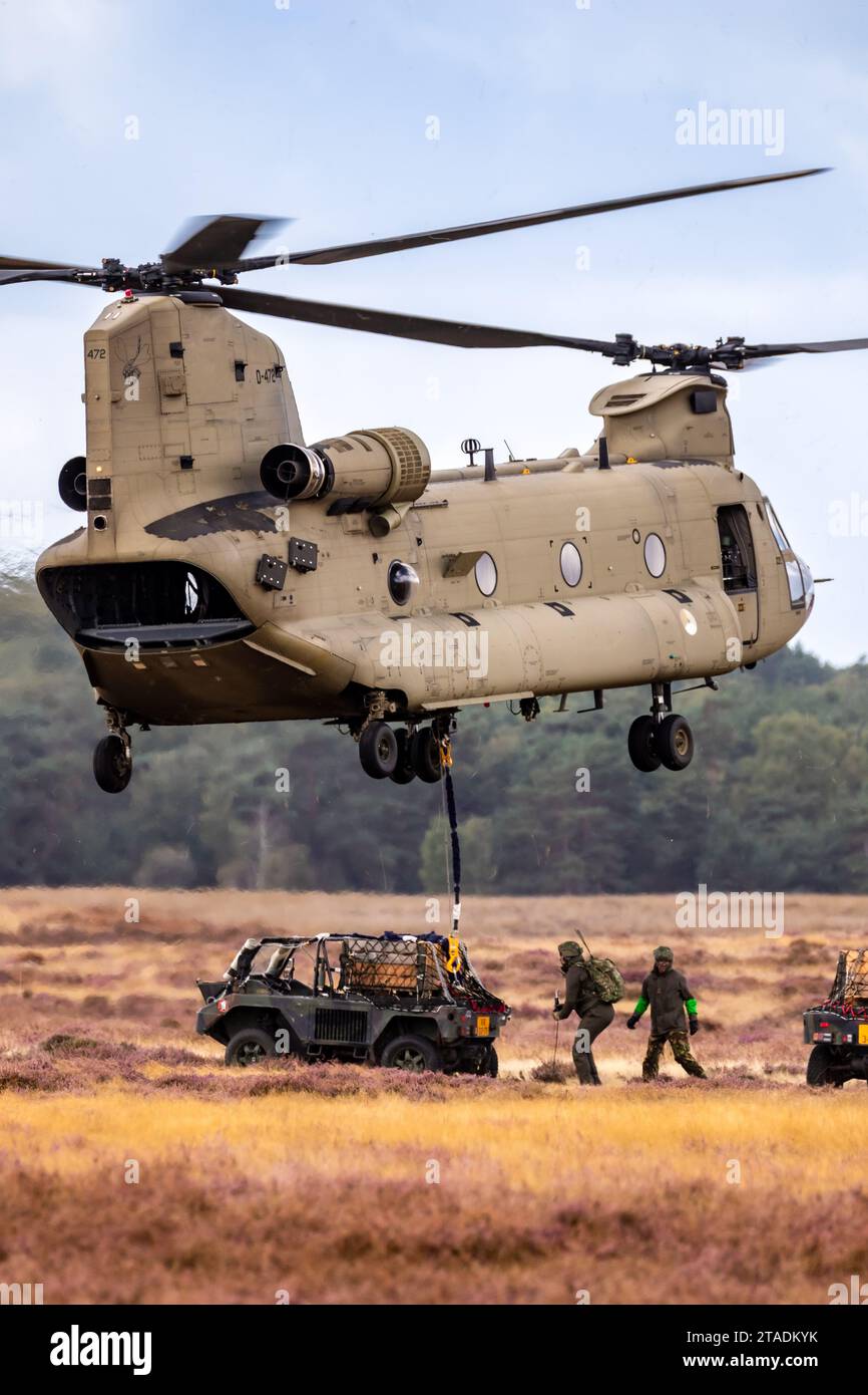 Soldati che attaccano un veicolo militare su tutti i terreni a un elicottero Boeing CH-47F Chinook. Ginkelse Heide, Paesi Bassi - 17 settembre 2022 Foto Stock