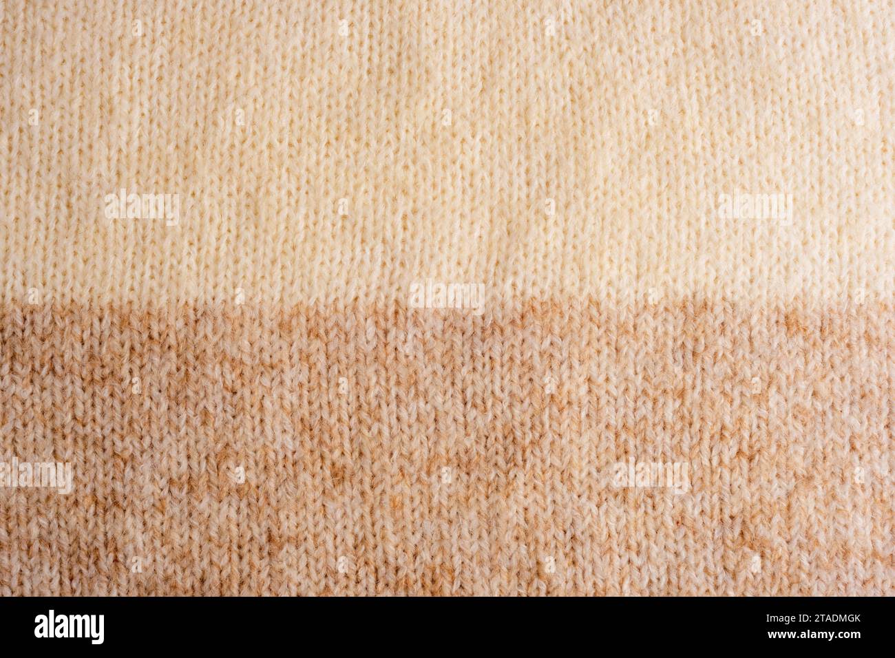 Maglione in maglia di lana beige e marrone, texture, sfondo. Foto Stock