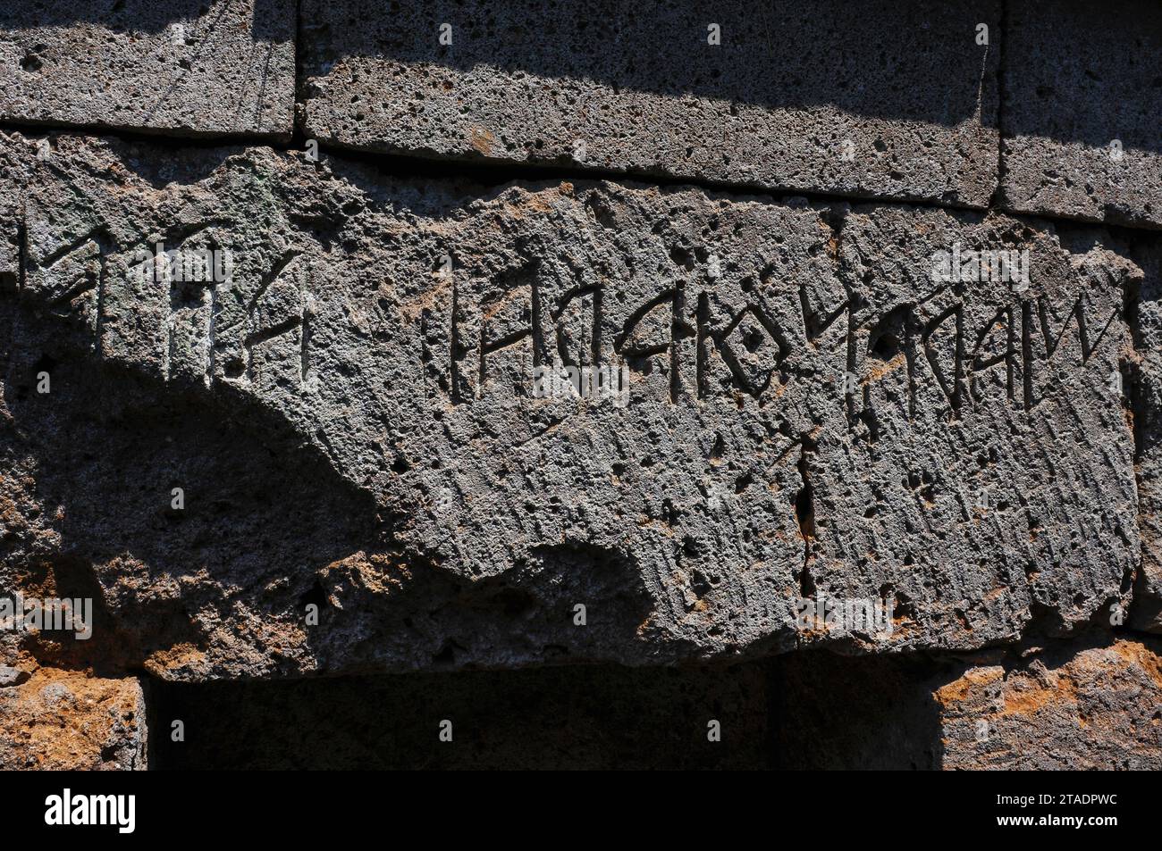 Su architrave sopra l'ingresso di una tomba a camera nella necropoli etrusca del Crocifisso del Tufo a Orvieto, Umbria, Italia, un'iscrizione in italico antico, lingua e scrittura etrusca. Il Crocifisso del Tufo era la necropoli settentrionale dell'antica città etrusca di Velzna o Velusna e qui furono sepolti cittadini etruschi dall'VIII secolo al III secolo a.C. La necropoli fu scoperta e scavata più di 2.000 anni dopo, nel XIX secolo. Foto Stock