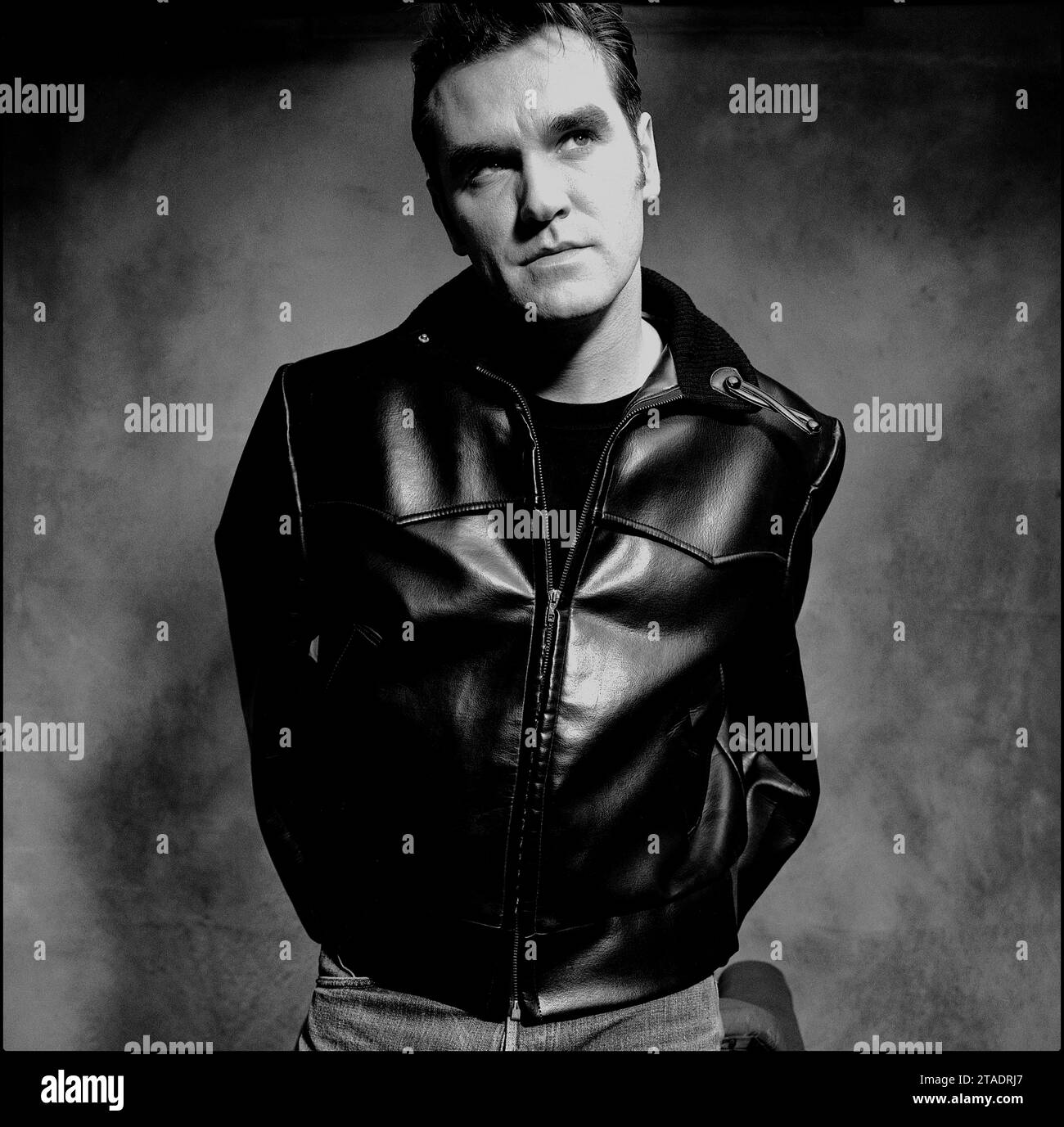 Potente ritratto a metà foto in bianco e nero della leggendaria rockstar, cantautore Morrissey in giacca di pelle e jeans blu per promuovere il suo singolo "Sunny" nel 1995 per Parlophone Records. Foto Stock