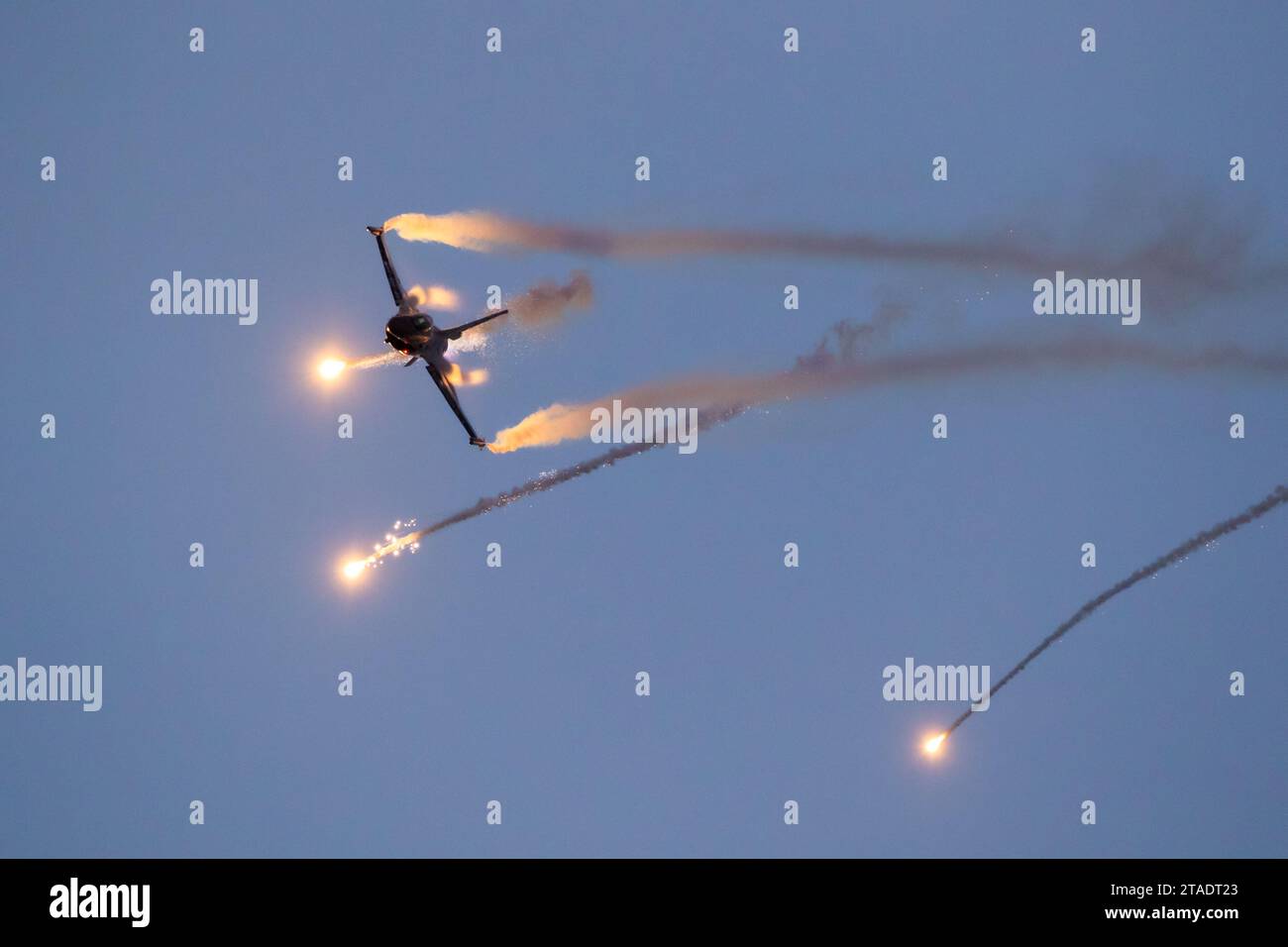 Un jet da combattimento militare in volo di combattimento sparando contro i bagliori contromisure nel cielo Foto Stock