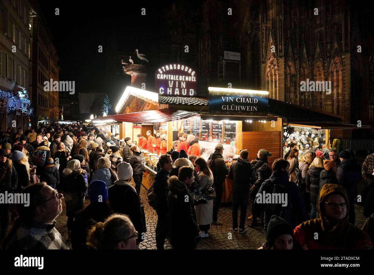 Gli amanti dello shopping riempiono le strade di Strasburgo, in Francia, durante i mercatini di Natale annuali e si godono il Vin Chaud o il vino speziato caldo. I mercati sono uno dei più antichi d'Europa, essendo operativi da oltre 400 anni. Si stima che oltre due milioni di persone visiteranno la città durante la stagione di Yule del 2023. Foto Stock