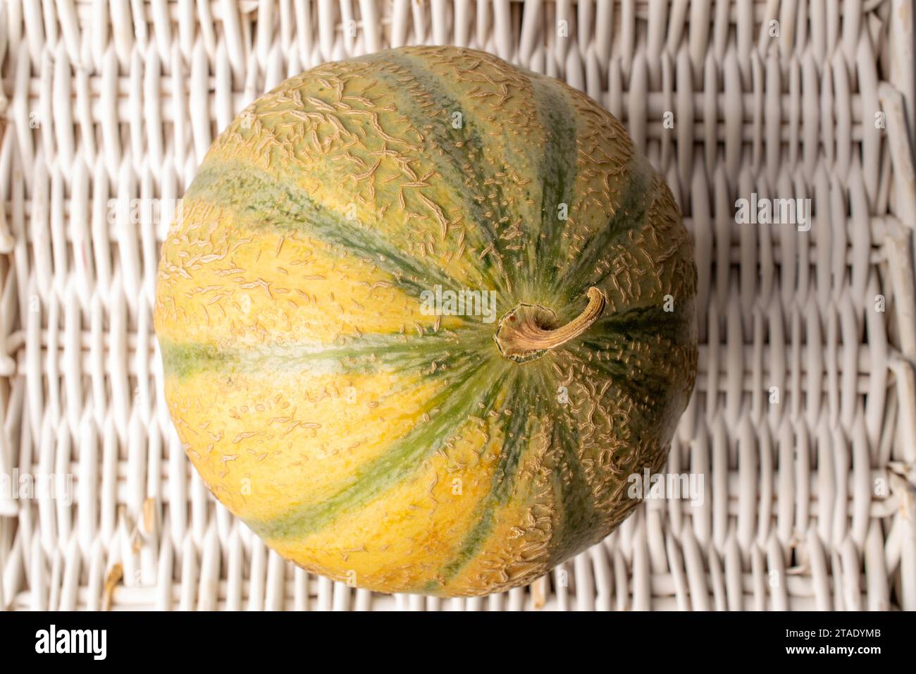 Un profumato melone organico su un vassoio di vite, primo piano, vista dall'alto. Foto Stock