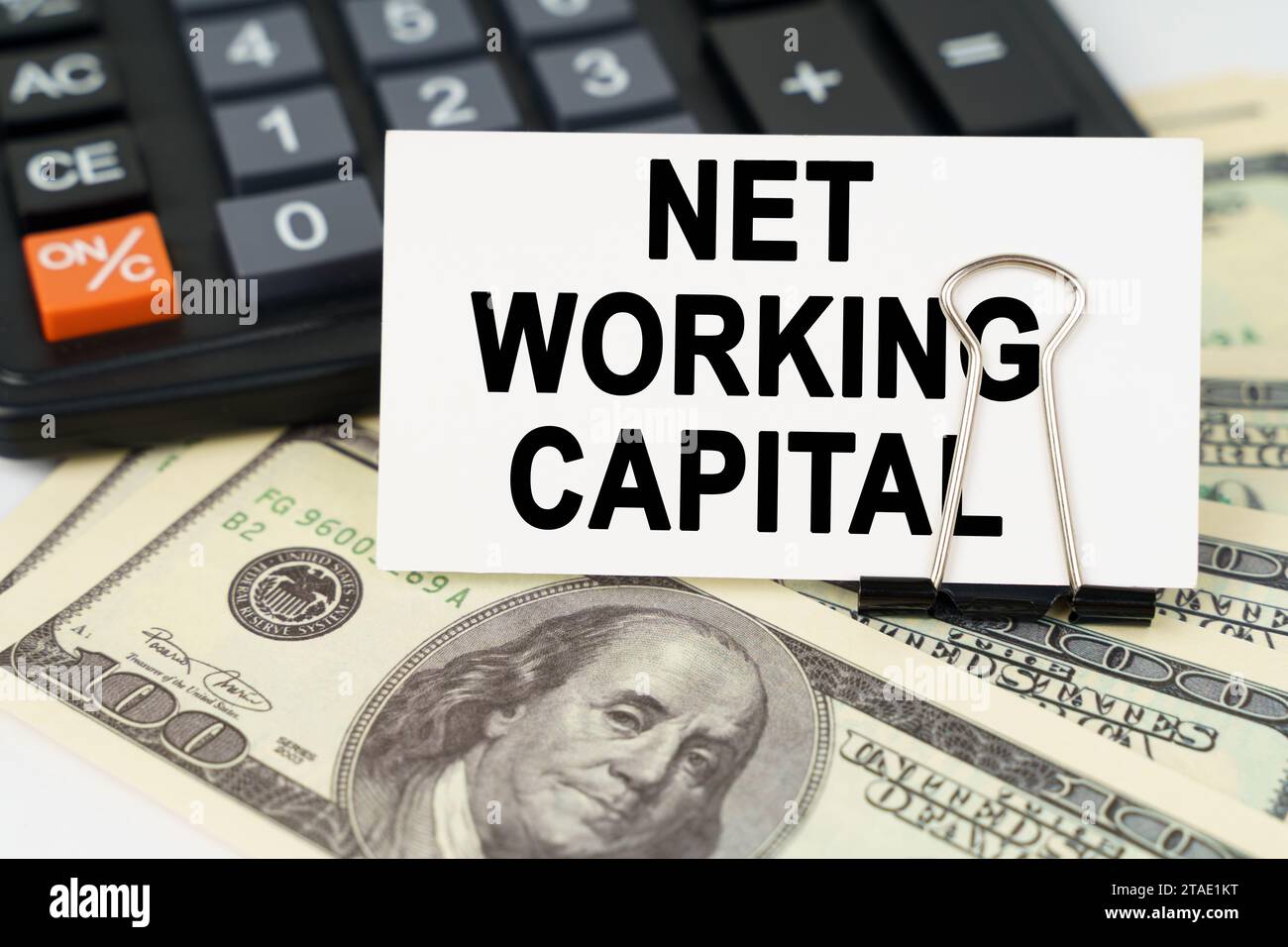 Concetto aziendale. Sui dollari c'è una calcolatrice e un biglietto da visita con l'iscrizione - NET WORKING CAPITAL Foto Stock