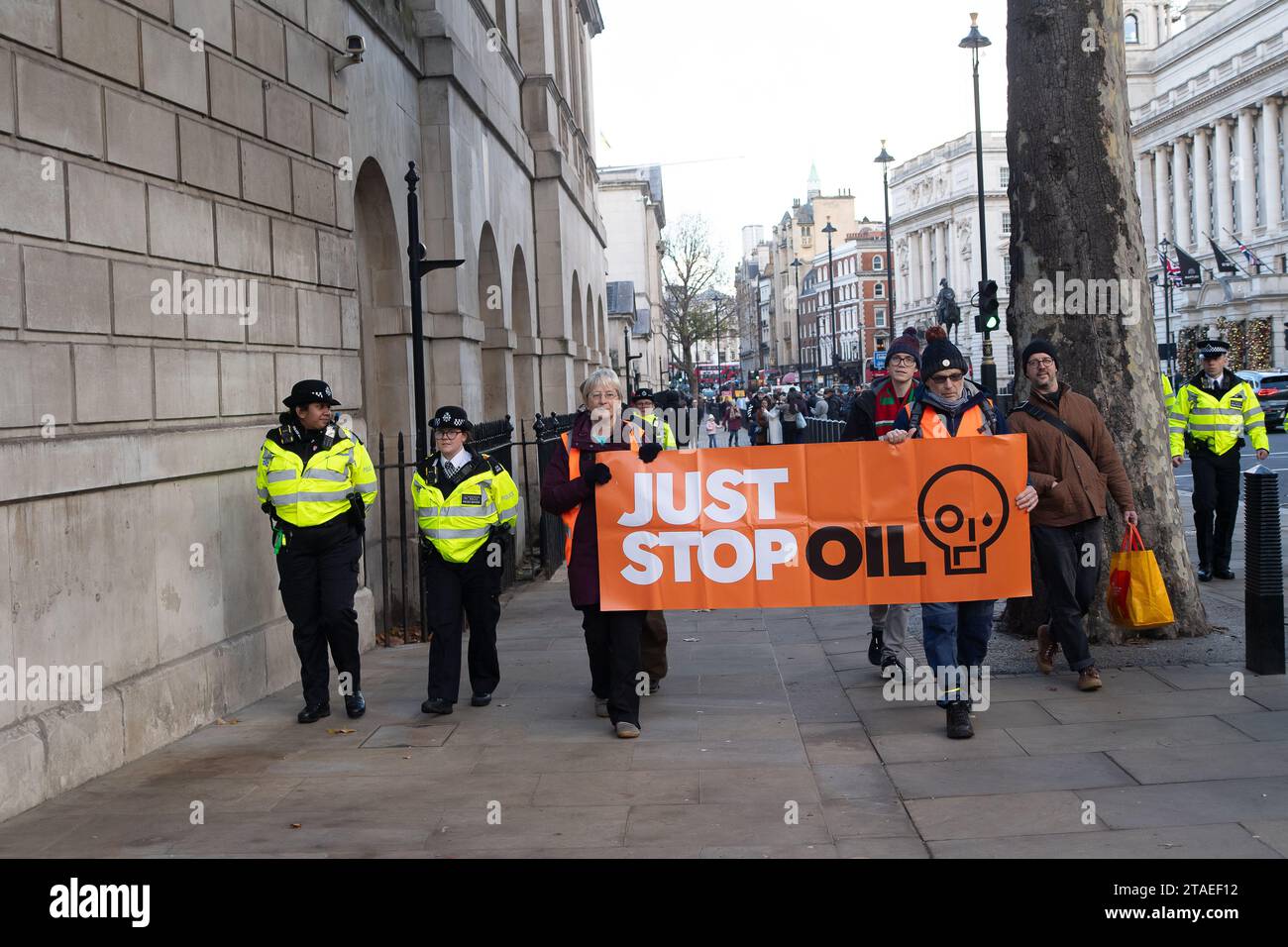 Whitehall, Londra, Regno Unito. 28 novembre 2023. I manifestanti Just Stop Oil sono tornati a protestare a Londra oggi. Hanno iniziato la loro protesta a Trafalgar Square. Quando due manifestanti anziani marciarono sulla strada fuori Downing Street, furono rapidamente arrestati e ammanettati dalla polizia del Met. La protesta Julie Redman, (L) 72, che è stata arrestata oggi è una nonna di sette figli di Fife. Ha detto: "Sono disperato per la crisi climatica. Sta accelerando a un ritmo allarmante, eppure il nostro governo sta ancora rilasciando nuove licenze per il petrolio e il gas. Sono i miei nipoti che sopporteranno il peso di clim Foto Stock