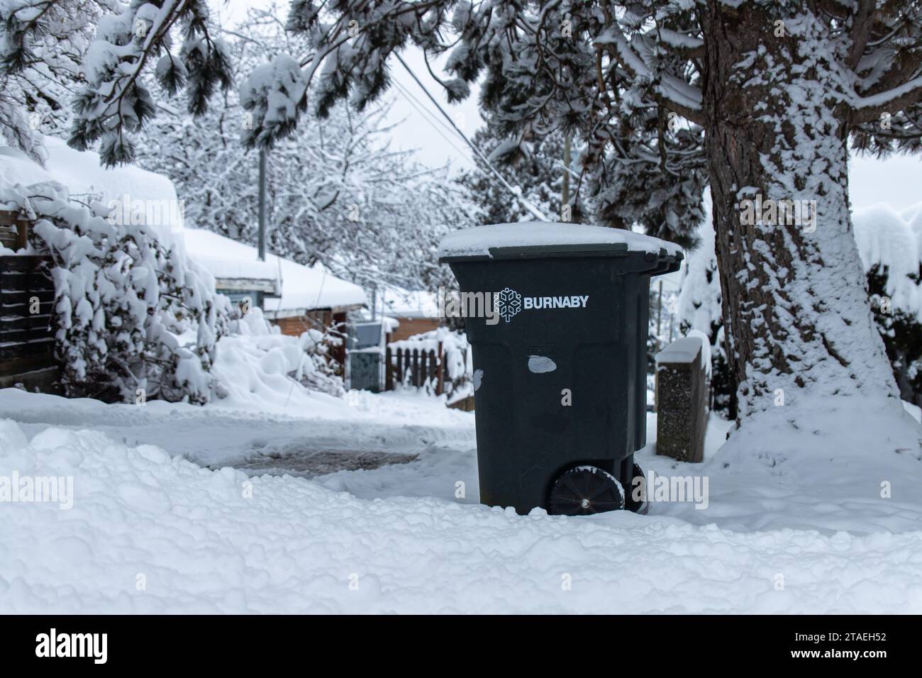 Burnaby, CANADA - 20 dicembre 2022 : immagine di un cestino con il logo della città di Burnaby stampato su di esso. Scena invernale con neve a terra. Foto Stock