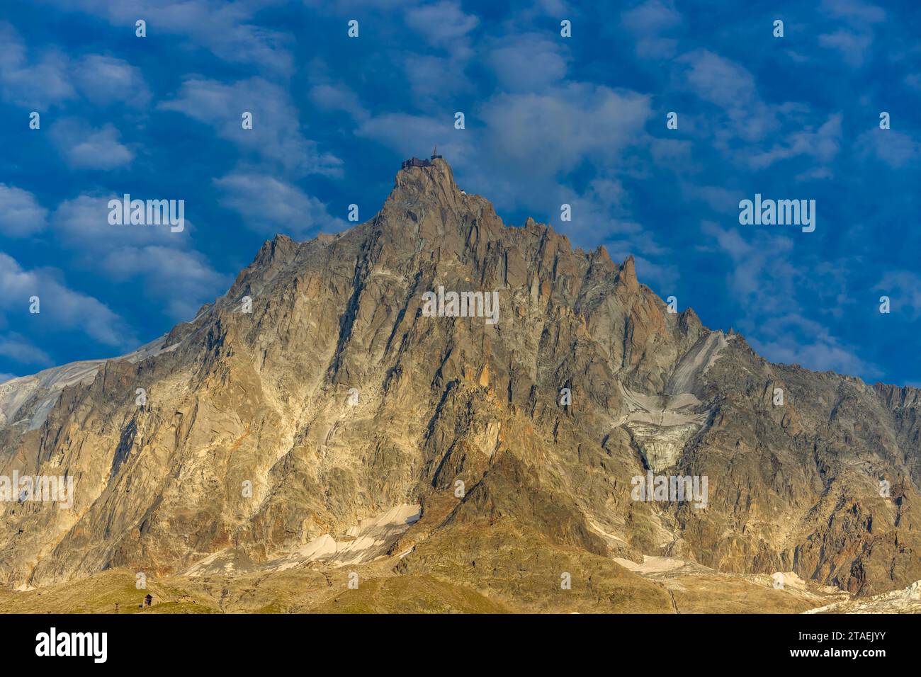 Cima rocciosa dell'Aiguille du Midi sopra il ghiacciaio blu di ghiaccio nell'alta catena montuosa delle Alpi in Francia. Paesaggio montano alpino della valle di Chamonix Foto Stock