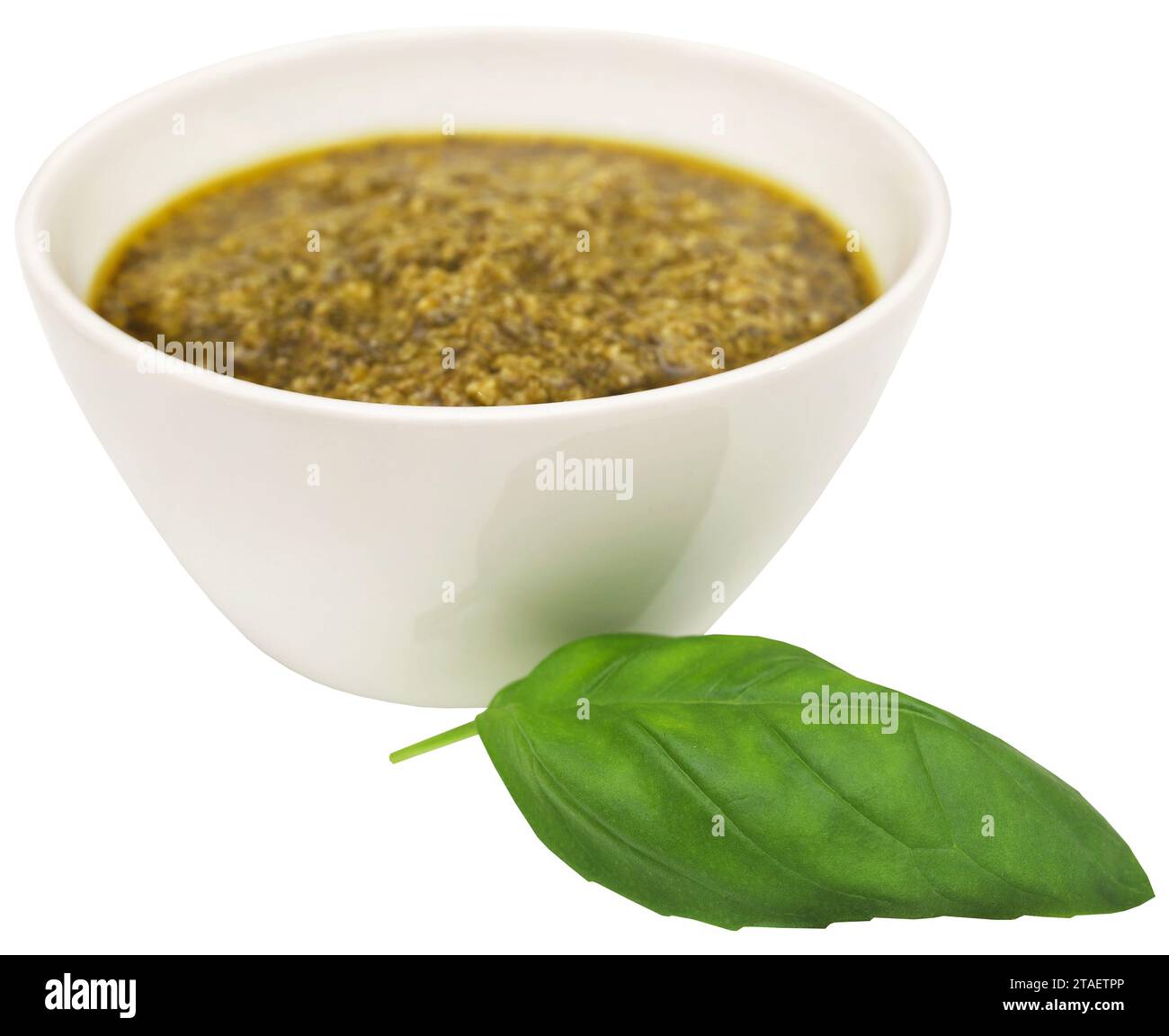 Foglie di basilico fresco con pesto in un recipiente Foto Stock