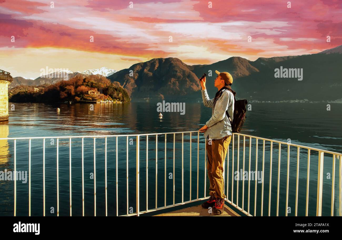 La vista stupenda del turista taiwanese fa un video dei bellissimi paesaggi del Lago di Como. Splendido tramonto nel cielo rosa - breve viaggio durante la settimana di Natale Foto Stock