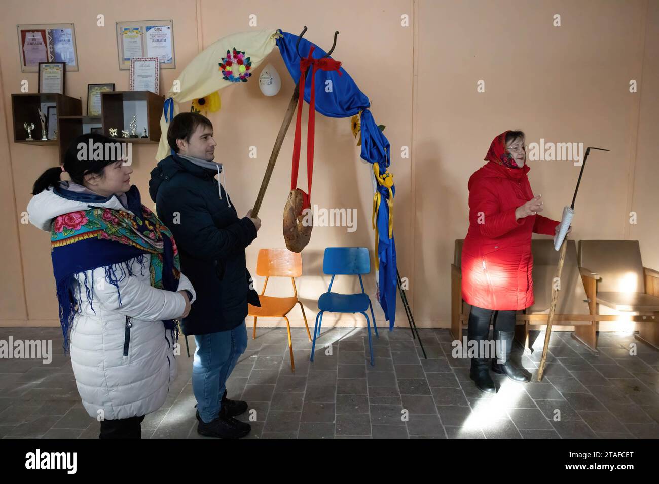 Rudnytske, Ucraina. 30 novembre 2023. Il giorno di San Andrew the Apostle, i residenti locali accolgono gli ospiti secondo le usanze popolari con pane legato a un poker nell'edificio di un club del villaggio distrutto nel villaggio di Rudnytske, regione di Kiev. Il villaggio di Rudnytske soffrì molto durante l'occupazione della regione di Kiev da parte dell'esercito russo nella primavera del 2022, molte case dei residenti locali e l'edificio scolastico locale furono distrutte. Credito: SOPA Images Limited/Alamy Live News Foto Stock