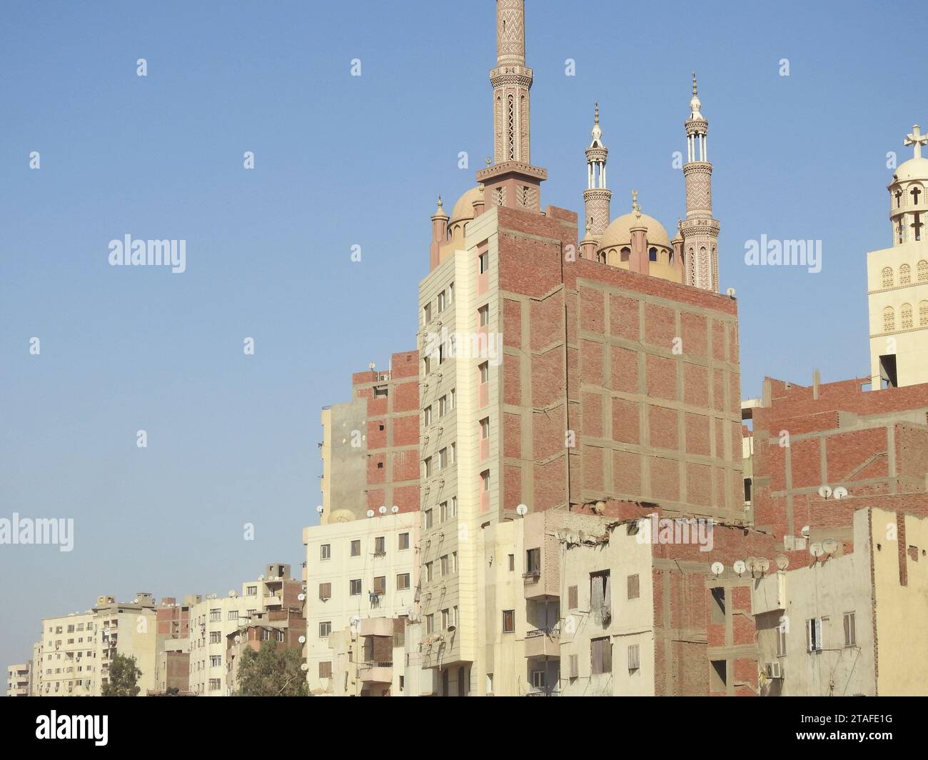 Giza, Egitto, settembre 28 2023: Cupole, minareti sopra un edificio, una moschea, minareti e cupole sopra un alto edificio, accanto a un campanile della chiesa, è Foto Stock