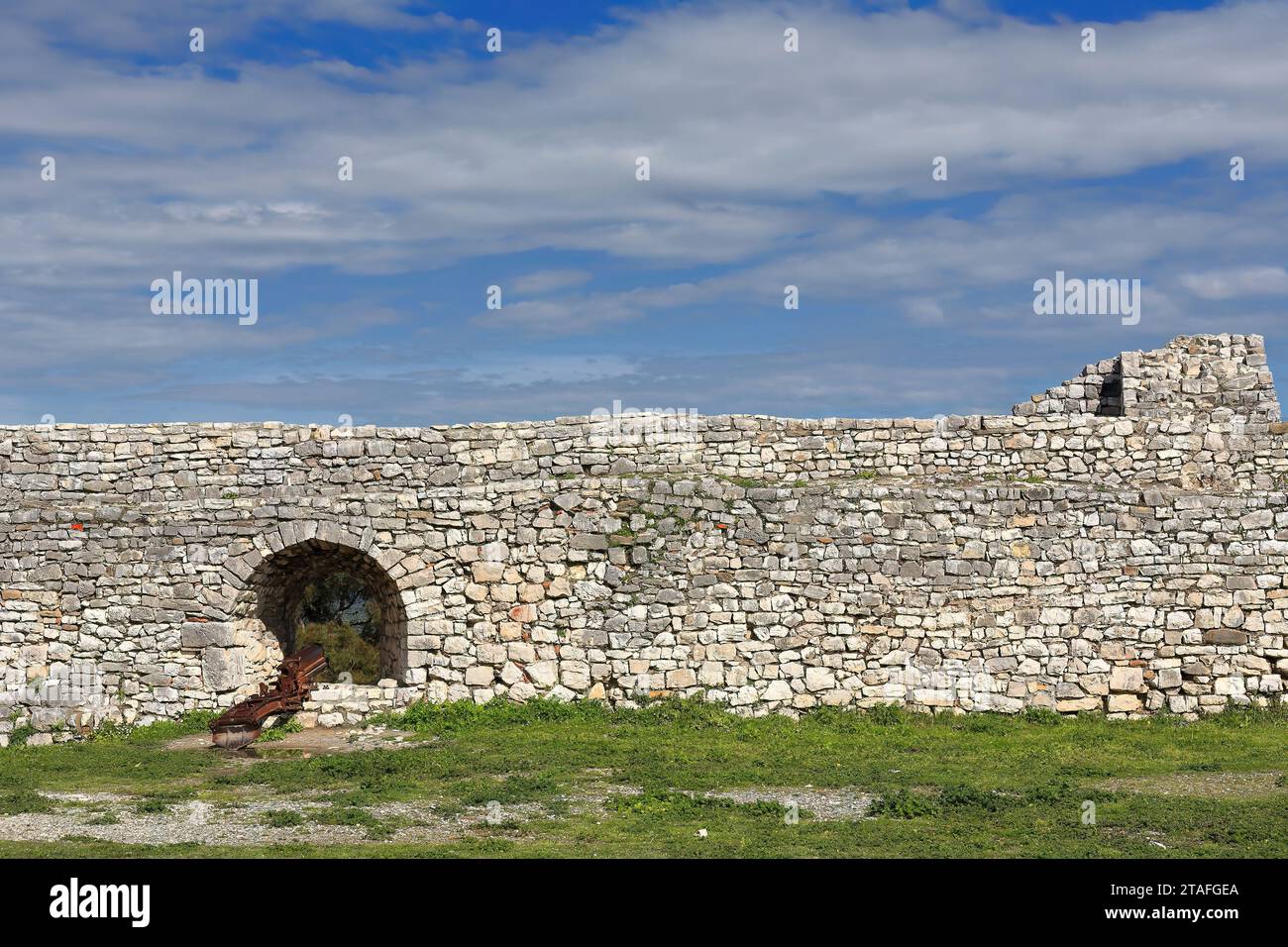 076 resti delle mura fortificate che circondano il quartiere di Kala-Castello-, vecchio cannone in una scappatoia. Berat-Albania. Foto Stock