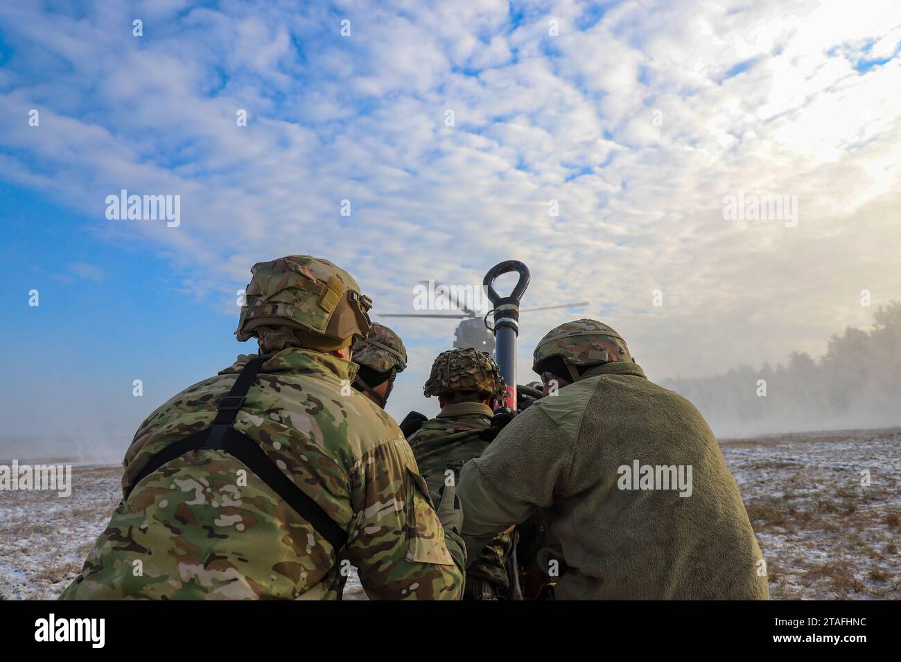 I soldati dell'esercito degli Stati Uniti assegnati alla Alpha Company, 129th Division Sustainment Support Battalion, parte della 3rd Division Sustainment Brigade 's Taskforce Provider, e gli aviatori assegnati alla 1st Combat Aviation Brigade, agganciano un carico da imbracatura a un elicottero UH-60 Black Hawk, a Powidz, in Polonia, il 30 novembre 2023. La 3rd Division Sustainment Brigade, che guida una forza multicompositiva di unità di sostegno, fornisce forze pronte e postulate, combattenti credibili e una presenza avanzata in Europa, consentendo una risposta rapida alla crisi e una deterrenza agli avversari. (Foto dell'esercito degli Stati Uniti di SPC. Elsi Delgado) Foto Stock