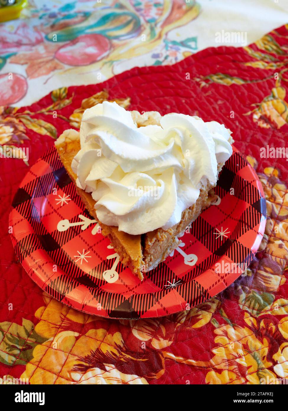 Fetta di torta di zucca con panna montata sopra per dessert su un piatto di carta durante il Ringraziamento o le vacanze di Natale. Foto Stock