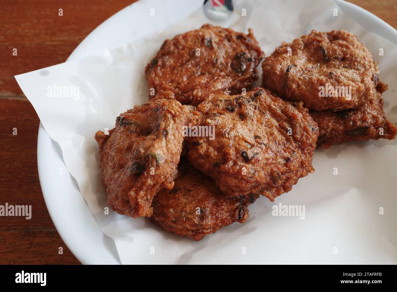 Torta di pesce tailandese fritta su piatto bianco. Foto Stock