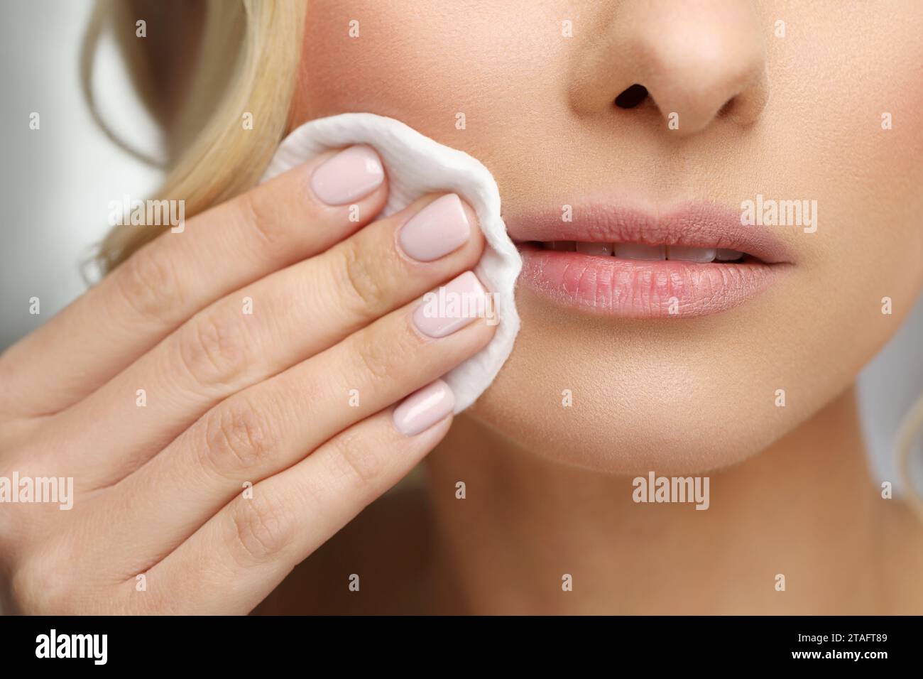 Donna che si toglie il trucco con un batuffolo di cotone, primo piano Foto Stock