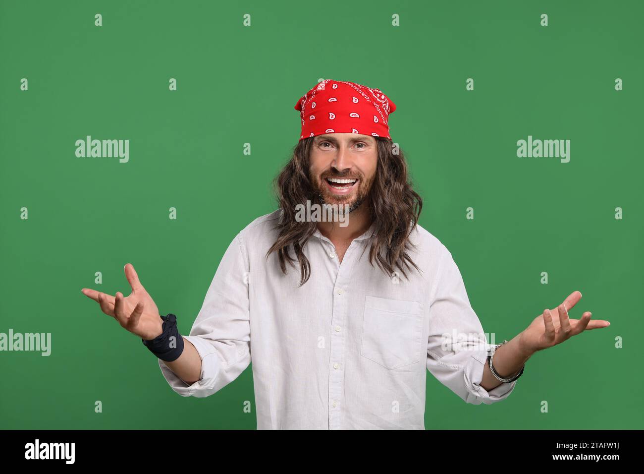 Elegante uomo hippie con camicia bianca su sfondo verde Foto Stock