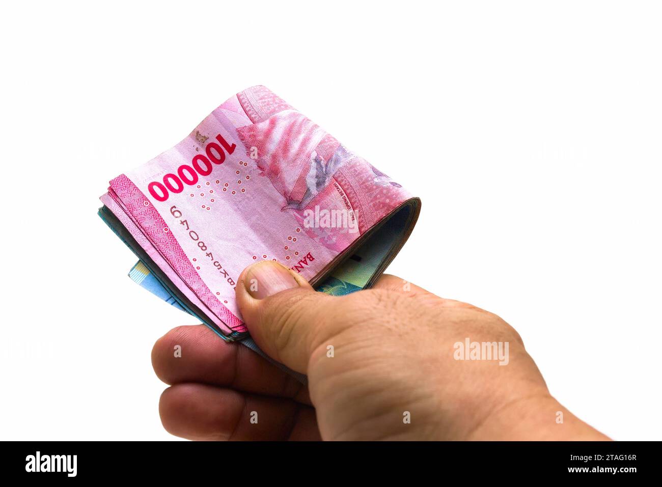 La Rupia indonesiana IDR è la valuta ufficiale dell'Indonesia. Mano di un uomo asiatico che tiene un po' di soldi per pagare. Concetto economico Business di investimento Foto Stock