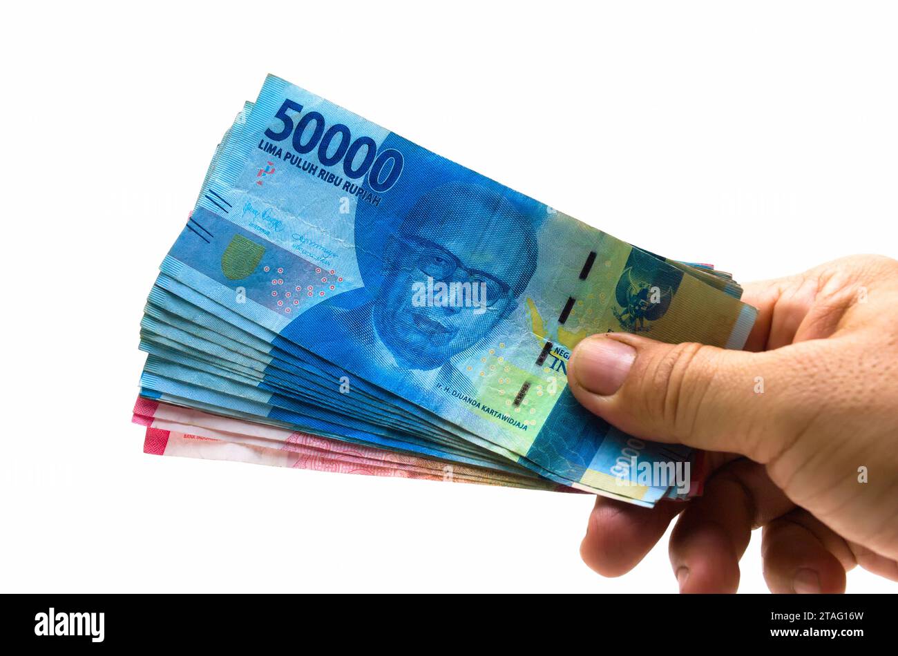 La Rupia indonesiana IDR è la valuta ufficiale dell'Indonesia. Mano di un uomo asiatico che tiene un po' di soldi per pagare. Concetto economico Business di investimento Foto Stock