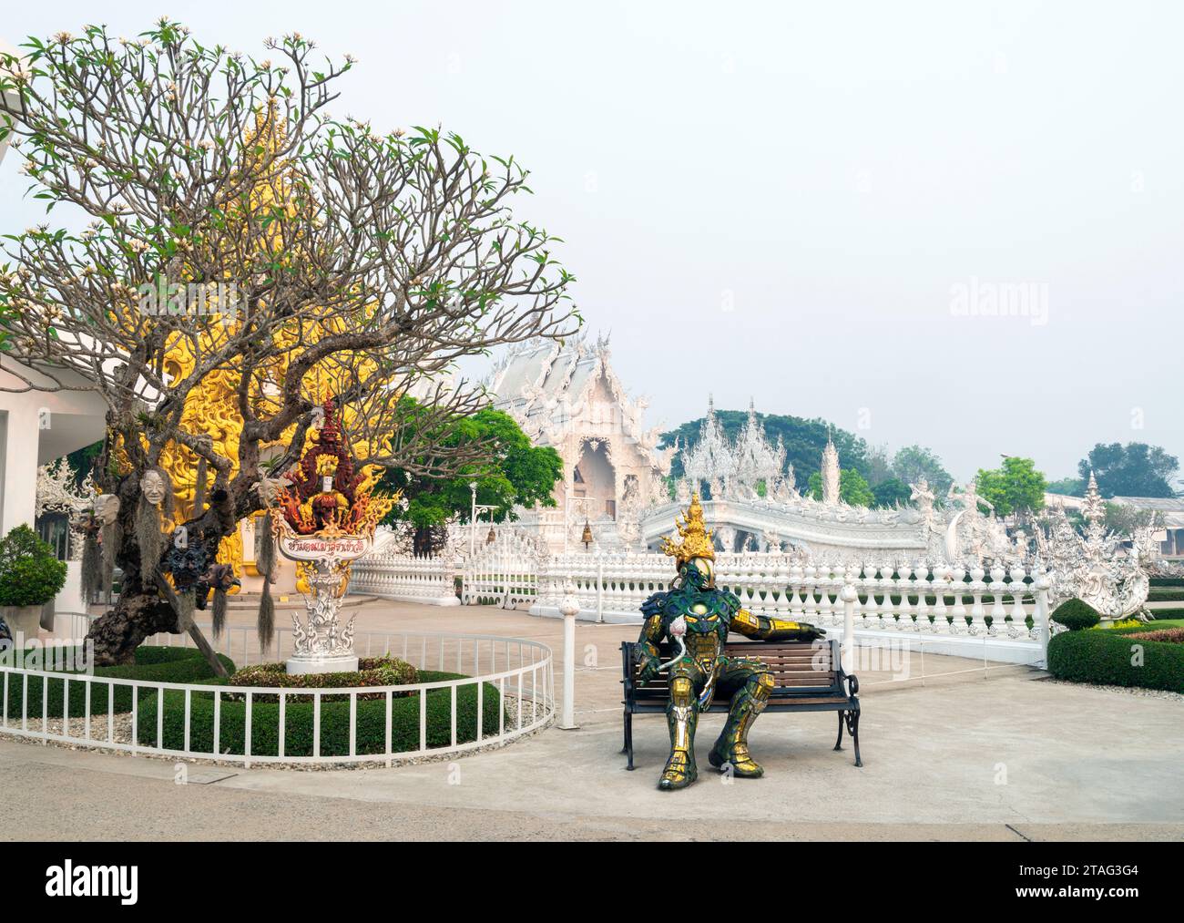 Chiang Rai, Thailandia - marzo 29 2023: Seduto su una panchina accanto ai cancelli d'ingresso del famoso tempio e delle principali opere d'arte, progettato dal maestro artista Chale Foto Stock