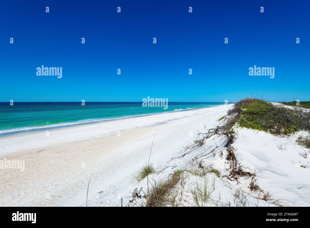 Crogiolatevi nella bellezza senza tempo delle coste baciate dal sole, dove le acque color smeraldo incontrano le sabbie bianche incontaminate, una tranquilla sinfonia di mare e serenità. Foto Stock