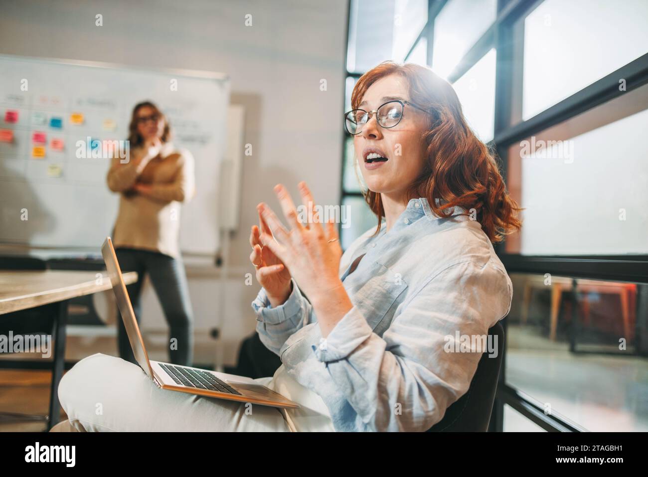 i professionisti, donne incluse, organizzano riunioni produttive in una moderna sala riunioni. Collaborando con i notebook, creano idee per cui fare brainstorming Foto Stock