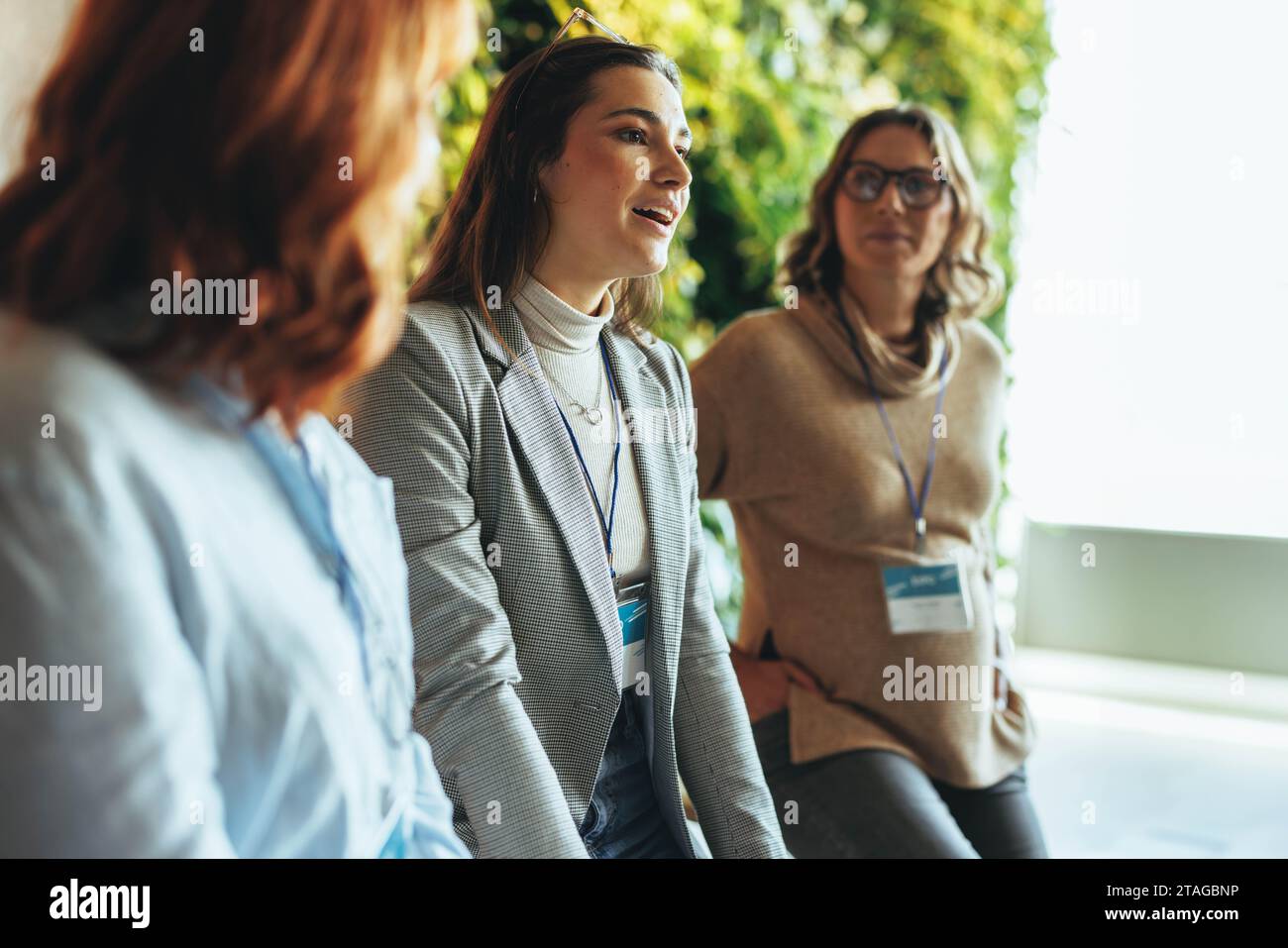 Professionisti impegnati in una discussione aziendale produttiva durante un evento. Colleghi in rete e collaborazioni, esemplificando un lavoro di squadra efficace. Dyna Foto Stock
