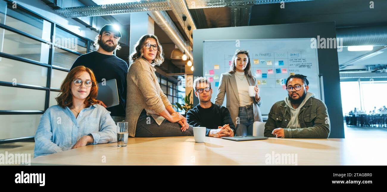 Ritratto di un team aziendale eterogeneo in un'azienda tecnologica che guarda la fotocamera. Mostrano lavoro di squadra e dedizione. Un team multiculturale sembra fiducioso Foto Stock