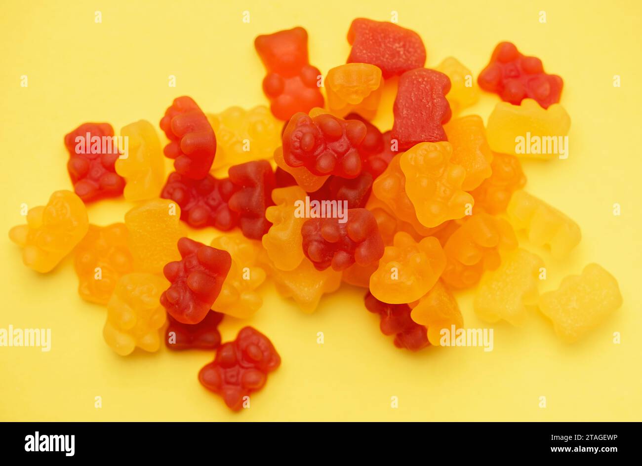 Vitamine per bambini, caramelle di orsi gommosi in gelatina su sfondo giallo Foto Stock