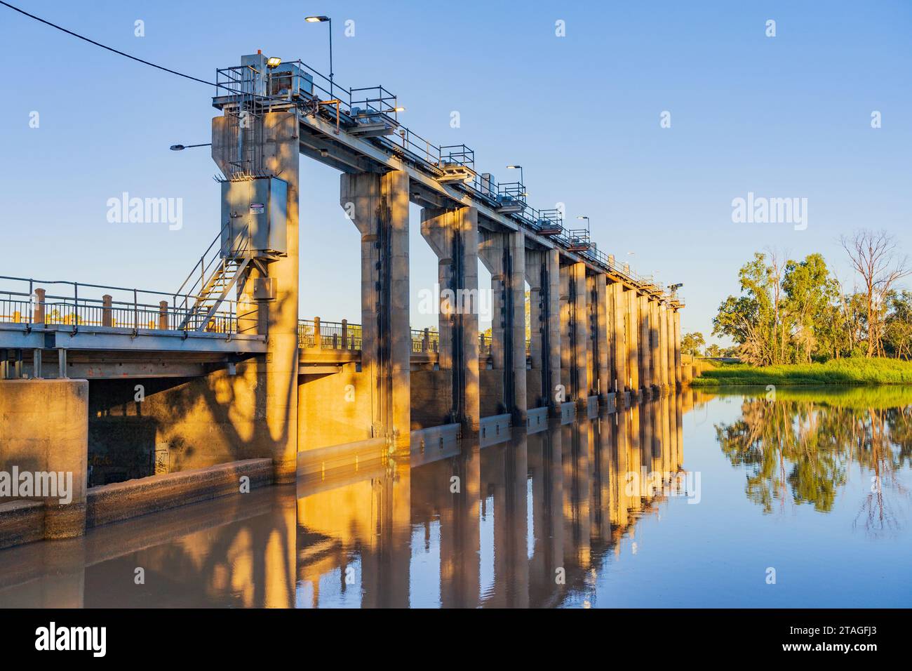 Una fila di porte di inondazione lungo una diga attraverso un ampio e tranquillo fiume a St George nel Queensland, Australia Foto Stock