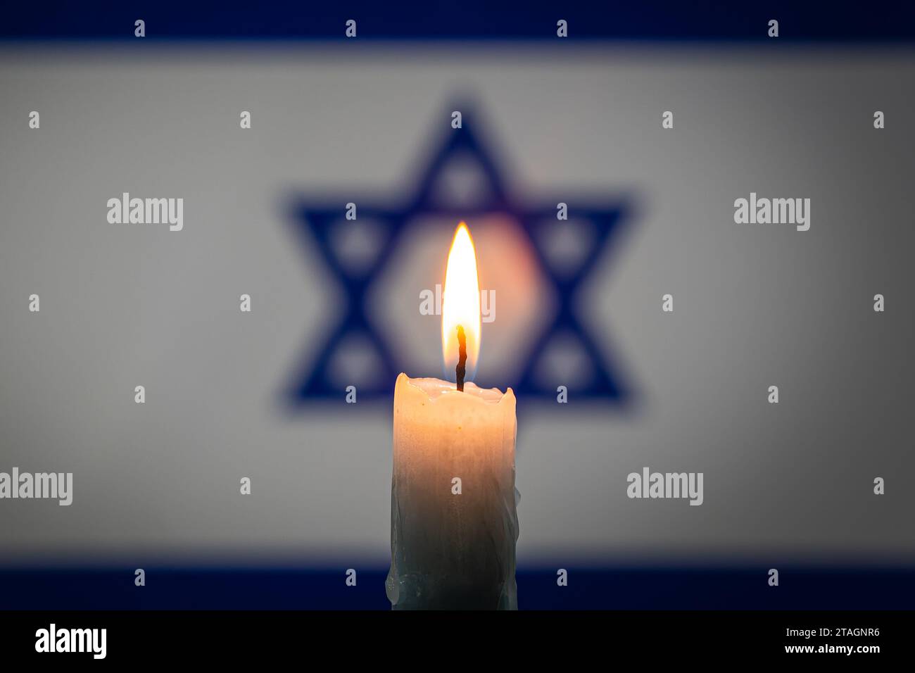Lutto nel paese Israele. Una candela accesa sullo sfondo della bandiera israeliana. Vittime del cataclisma o del concetto di guerra. Memorial Day dell'Olocausto, Remem Foto Stock