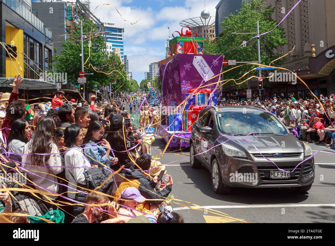 Gli streamer di carta coprono la folla alla Farmers Christmas Parade in Queen Street, Auckland, nuova Zelanda Foto Stock
