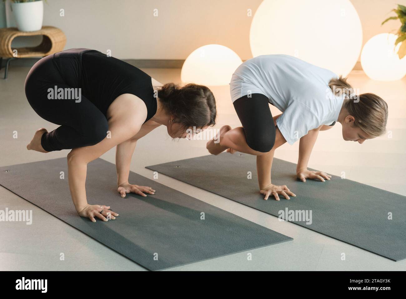 Mamma e figlia adolescente fanno ginnastica insieme nella sala fitness. Una donna e una ragazza si allenano in palestra. Foto Stock