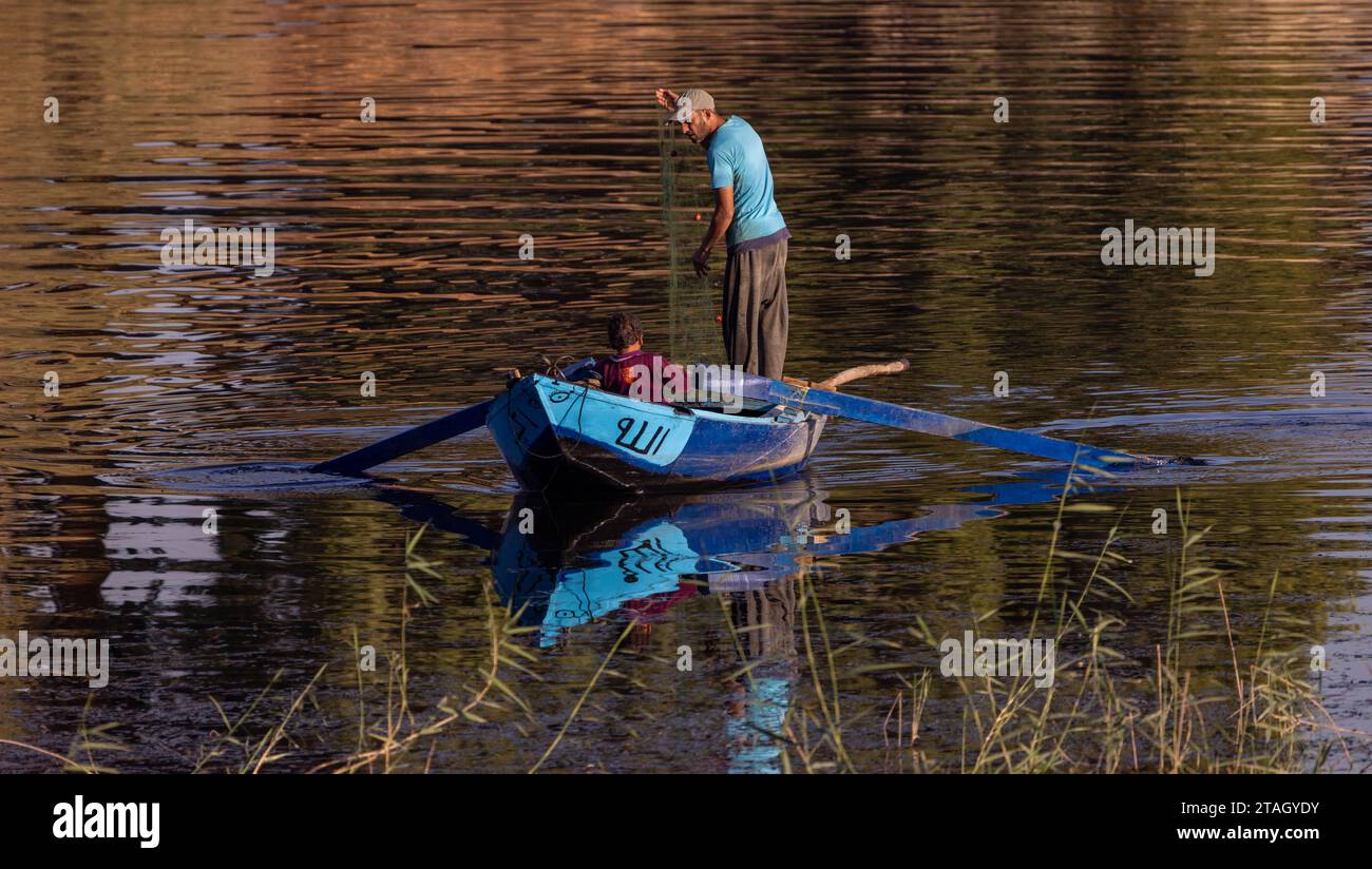 pescatore e figlio in barca a remi sul Nilo, Luxor, Egitto Foto Stock