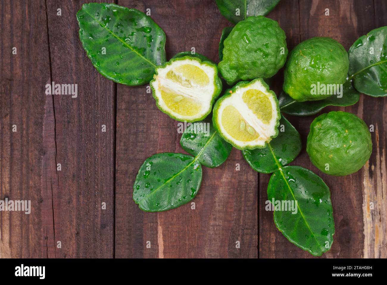 Bergamotto fresco della natura poggiato su un tagliere di legno da utilizzare come cuoco e nutriente per la cura dei capelli e della pelle. Foto Stock