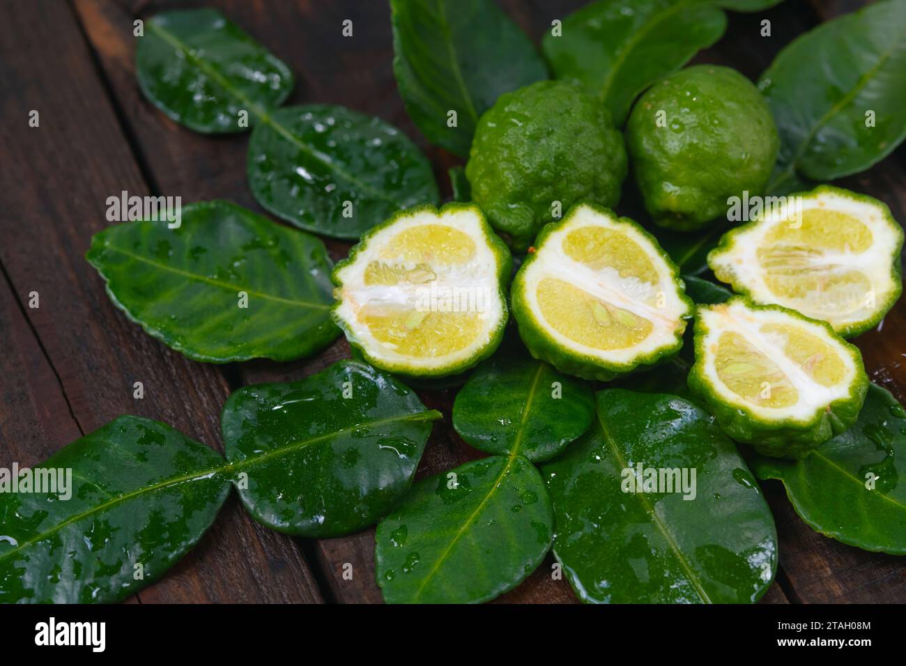 Bergamotto fresco della natura poggiato su un tagliere di legno da utilizzare come cuoco e nutriente per la cura dei capelli e della pelle. Foto Stock