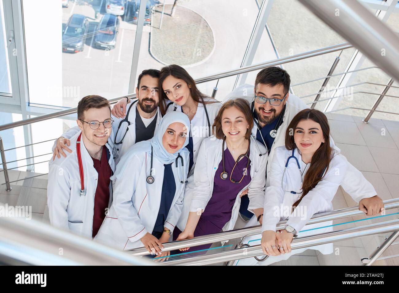 Un gruppo di felici medici sorridenti nel corridoio dell'ospedale. Studenti di medicina di diverse razze in kapmus Foto Stock