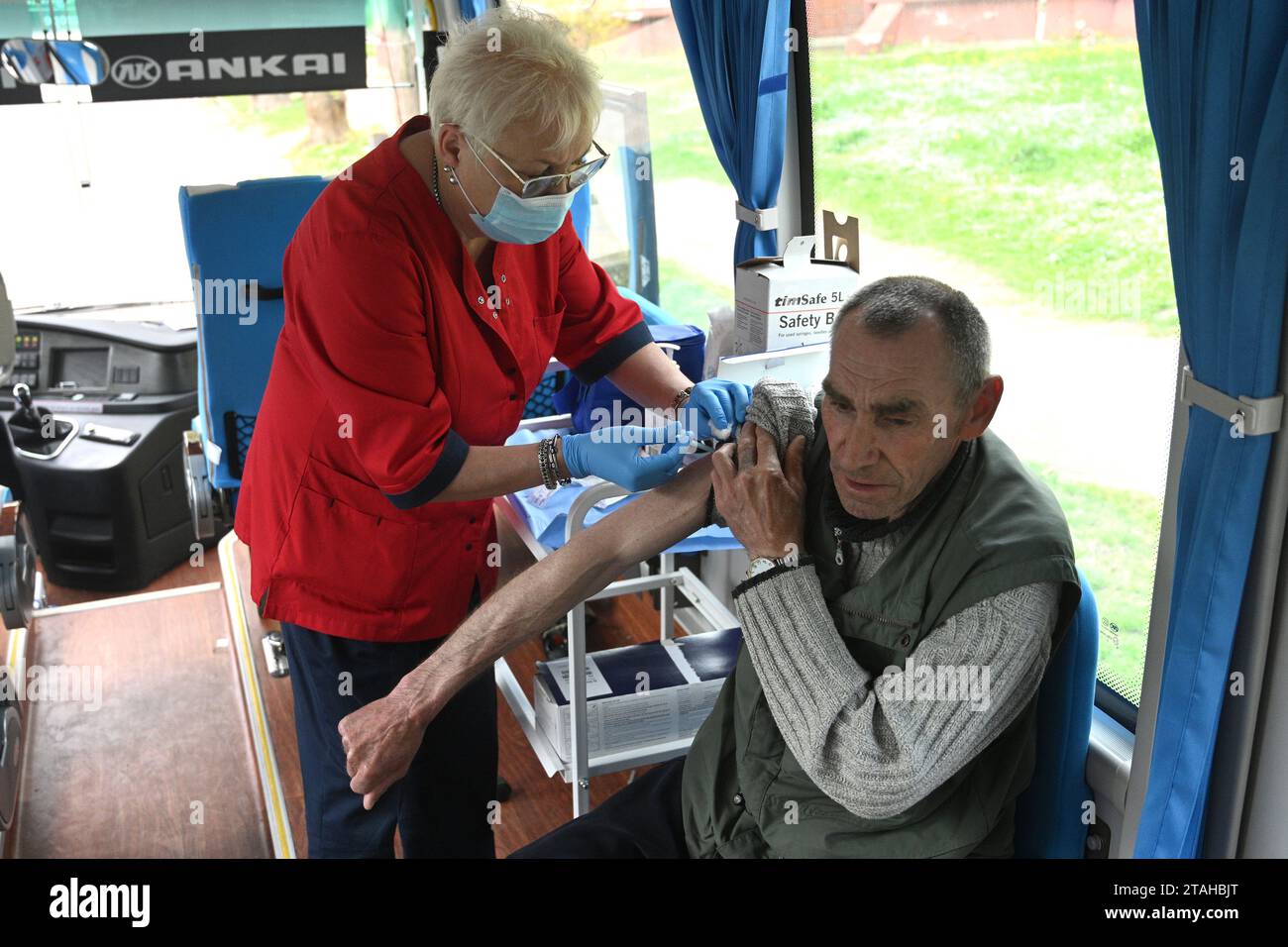 Leopoli, Ucraina - 25, 2023: Un infermiere somministra un uomo nel punto di vaccinazione mobile un vaccino DTaP. Foto Stock