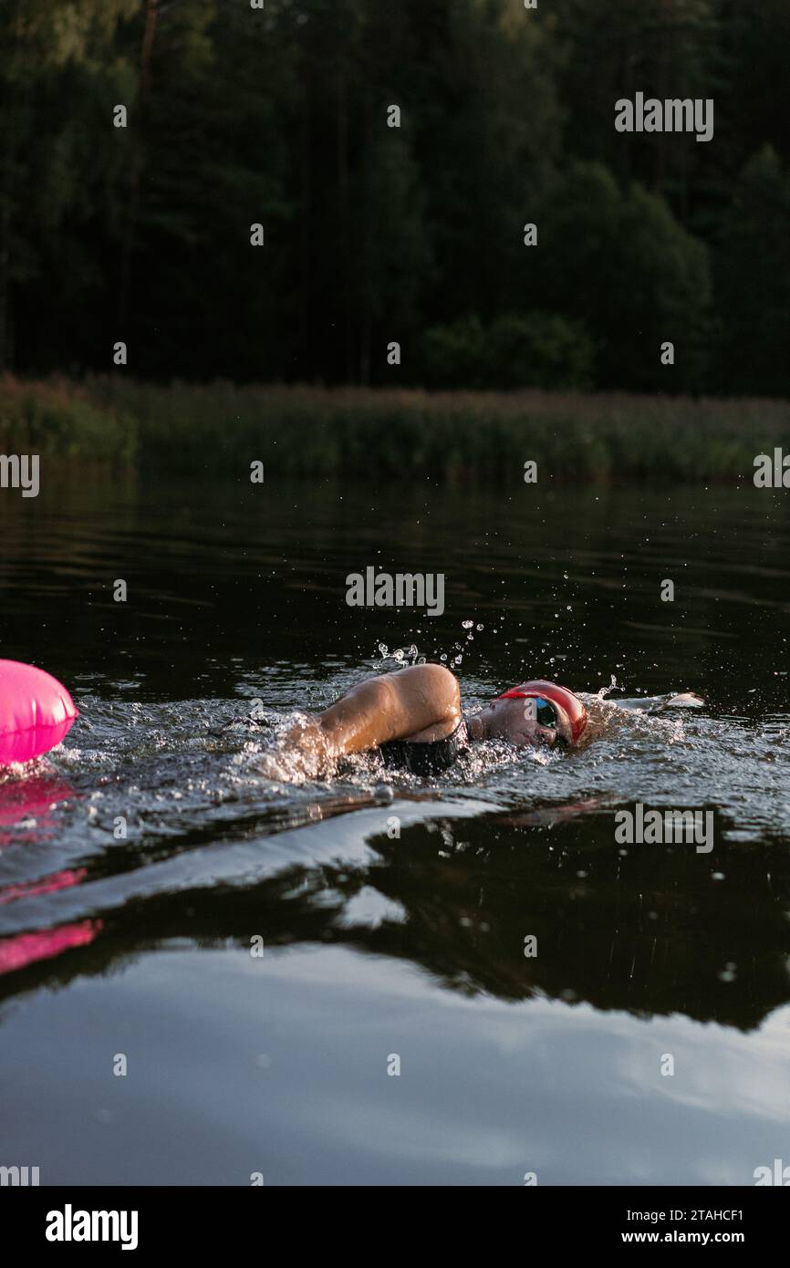 Nuotatore professionista in muta nuota in mare aperto su un lago. Foto Stock
